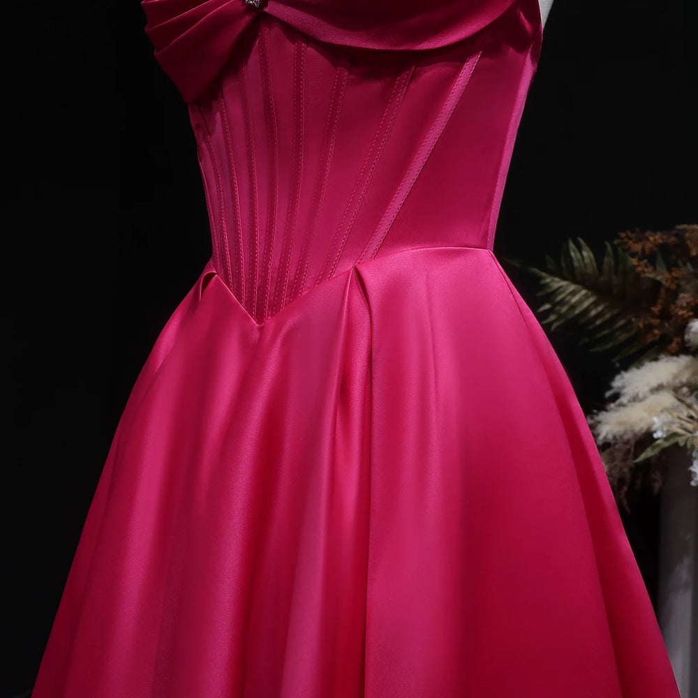 Pink evening gown with a bow detail on a black background