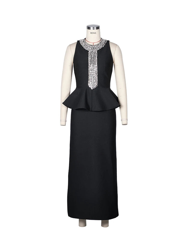 Black dress with a peplum top and embellishments on a mannequin against a white background