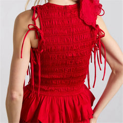 Woman wearing red ruffled smocked crop top with puff sleeves and fitted waist