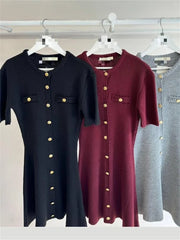 Three button-up dresses in black, red, and gray hanging on a rack.
