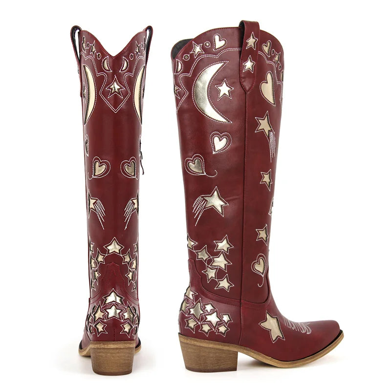 Red cowboy boots with star and heart patterns on a white background