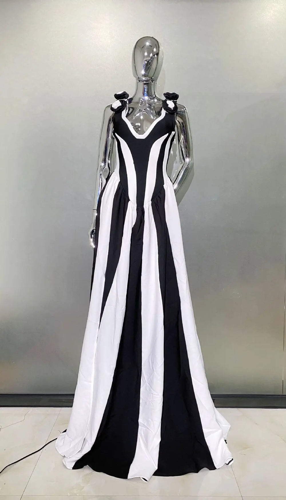Black and white striped dress on a mannequin against a neutral background