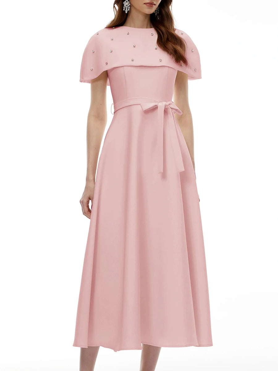 Close-up of the embellished neckline on a pink midi dress