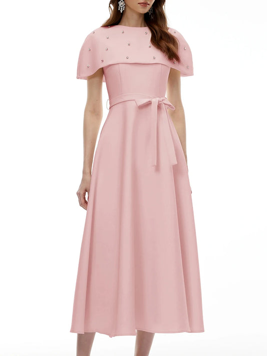 Close-up of the embellished neckline on a pink midi dress