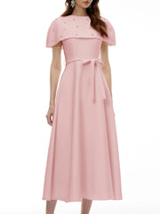 Close-up of the embellished neckline on a pink midi dress