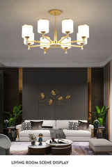 Modern LED chandelier with glass pendants, casting a warm glow in a stylish living room. Golden Atelier 3