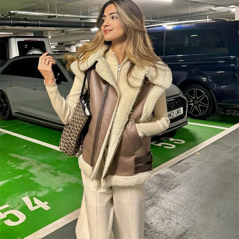 Woman in a stylish coat standing in a parking garage with cars around her.