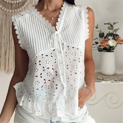 White lace-trimmed top worn by a person, with a decorative background.