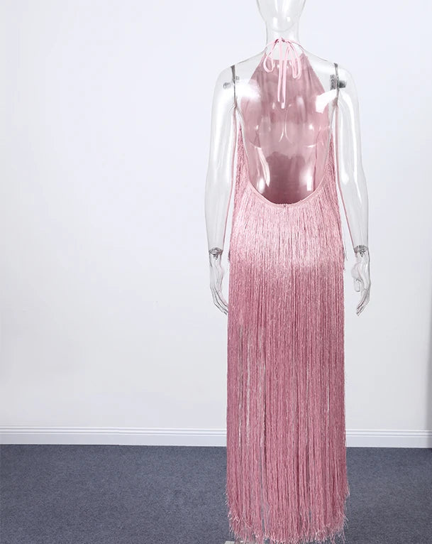 Pink fringe dress on a mannequin against a white wall with a plant in the corner.