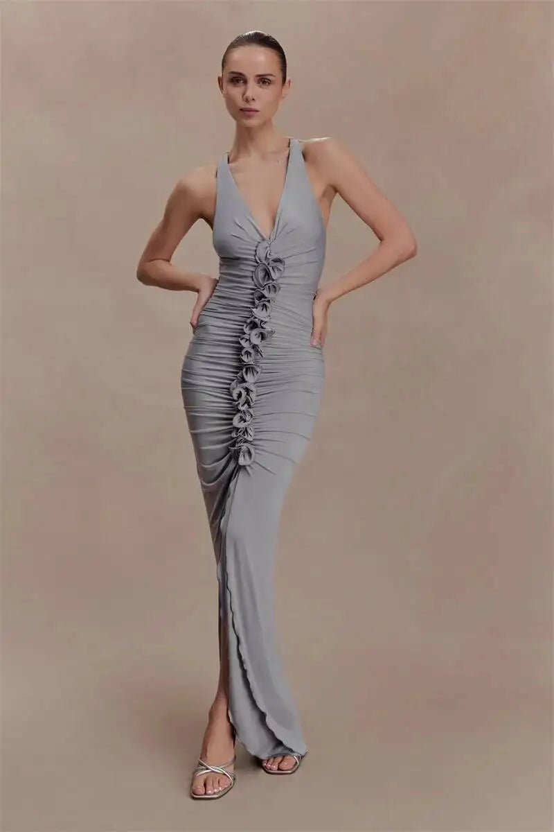 Woman wearing a gray evening gown with a ruched design on a beige background