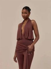 Close-up of a woman in a brown draped halter top and matching wide leg pants set.