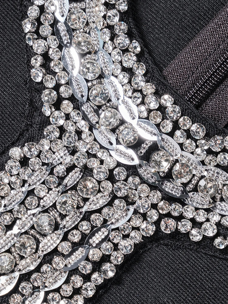 Close-up of a black garment with intricate silver beadwork