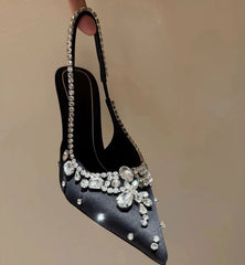 Close-up of a black pointed toe slingback pump with crystal embellishments