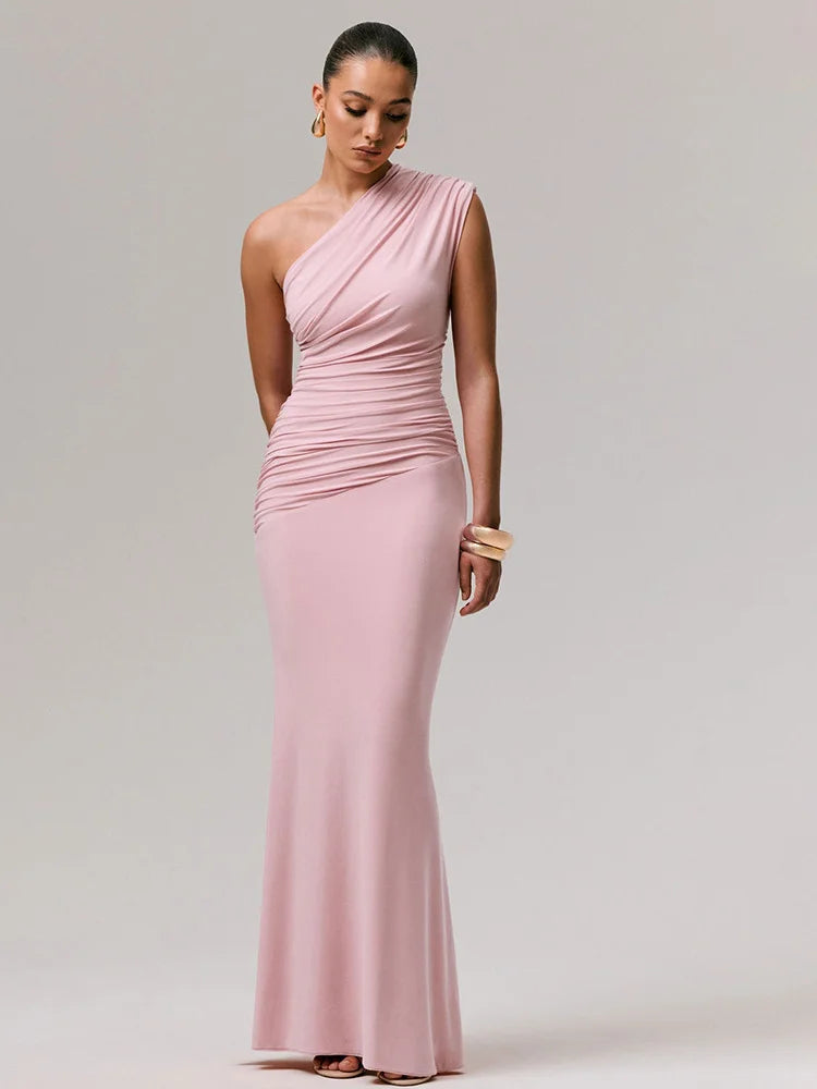 Model posing in a pink one-shoulder ruched gown