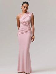 Model posing in a pink one-shoulder ruched gown