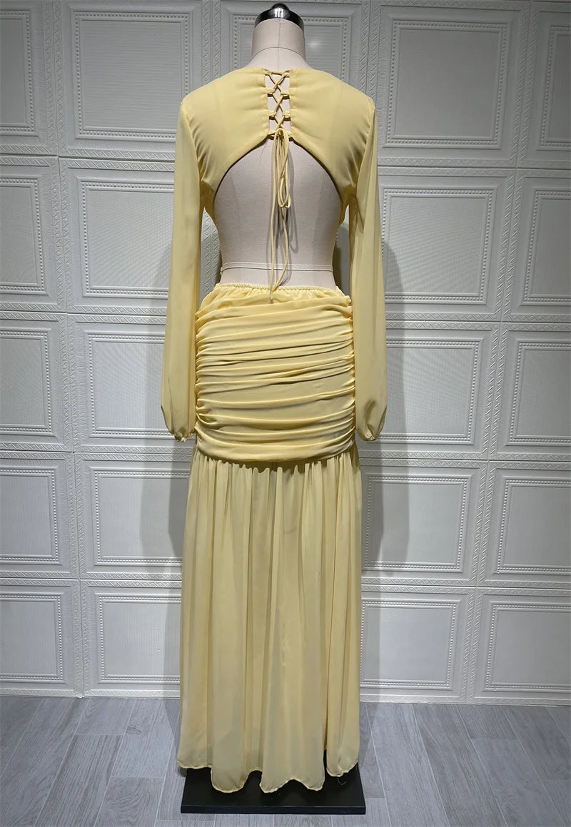 Yellow dress on a mannequin against a gray paneled wall