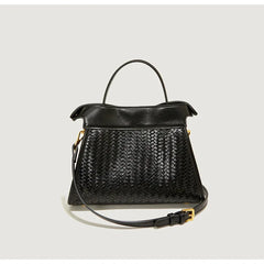 Black woven handbag with a strap on a light gray background