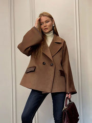 A model wearing a stylish leather patchwork wool jacket with a double-breasted closure and lapel collar.