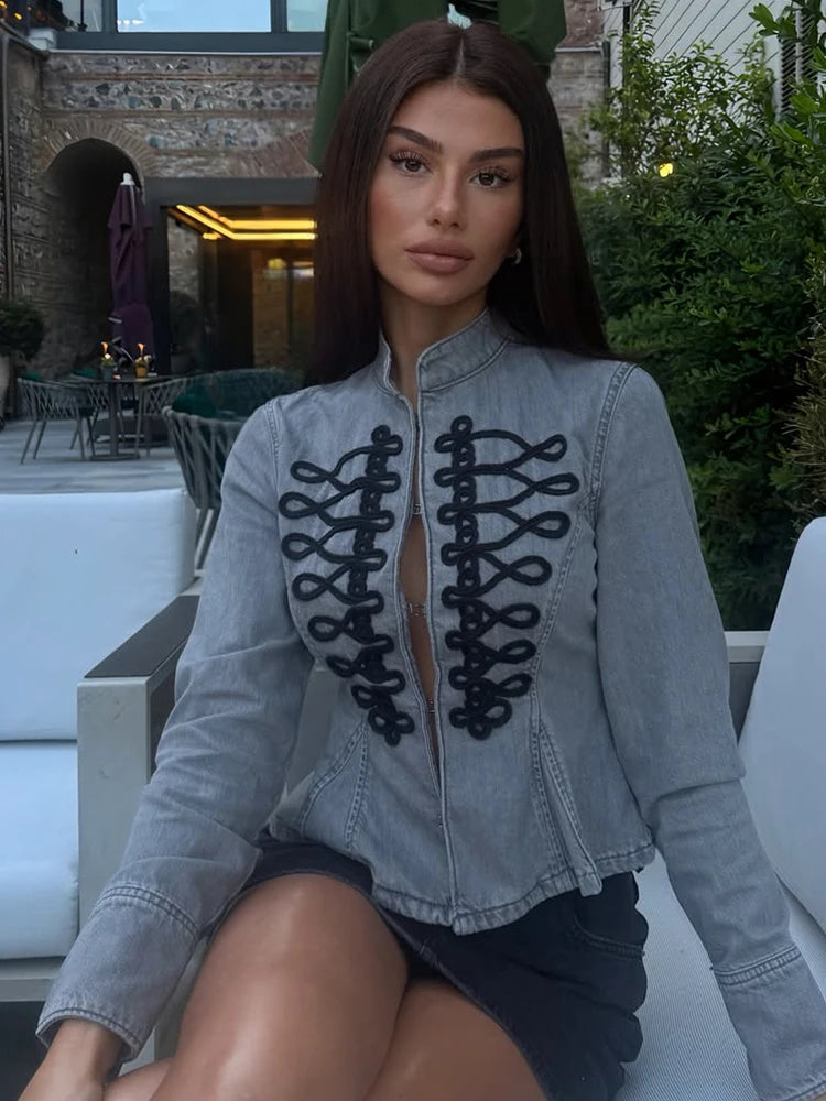 Close-up of the black embroidery on the grey denim jacket.