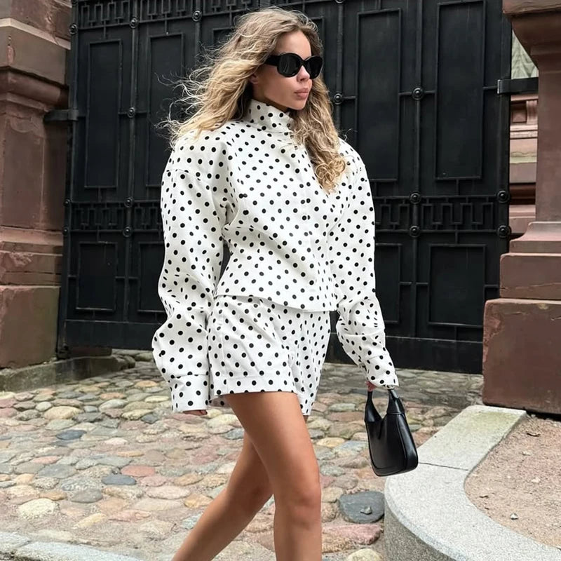 Woman in a polka dot outfit walking outdoors.