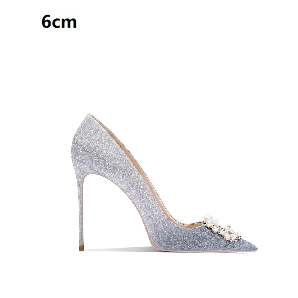 High-heeled shoe with pearl embellishments on a white background
