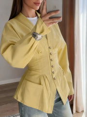 Person wearing a yellow jacket taking a mirror selfie indoors.