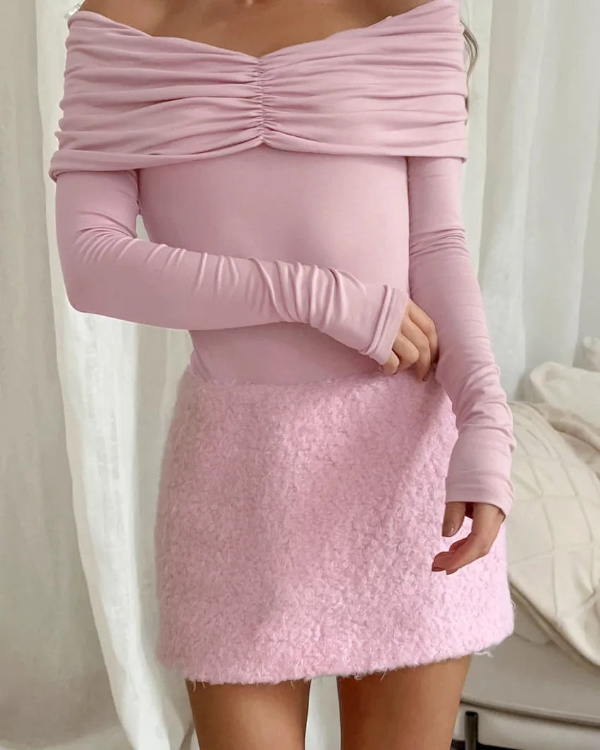 Pink long-sleeve top and skirt set against a white background