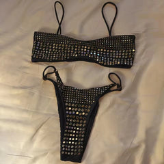 Black embellished bikini set laid flat on a white surface.