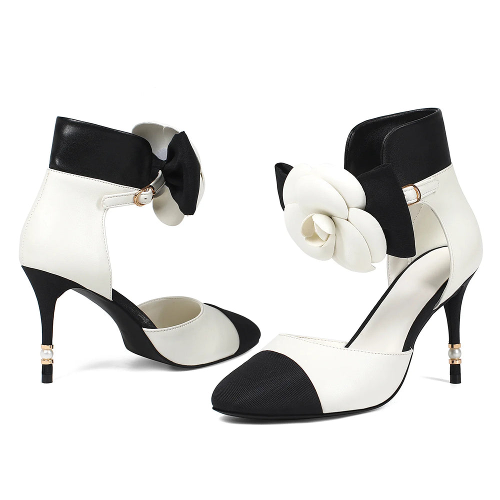 Black and white high-heeled shoes with decorative elements on a white background