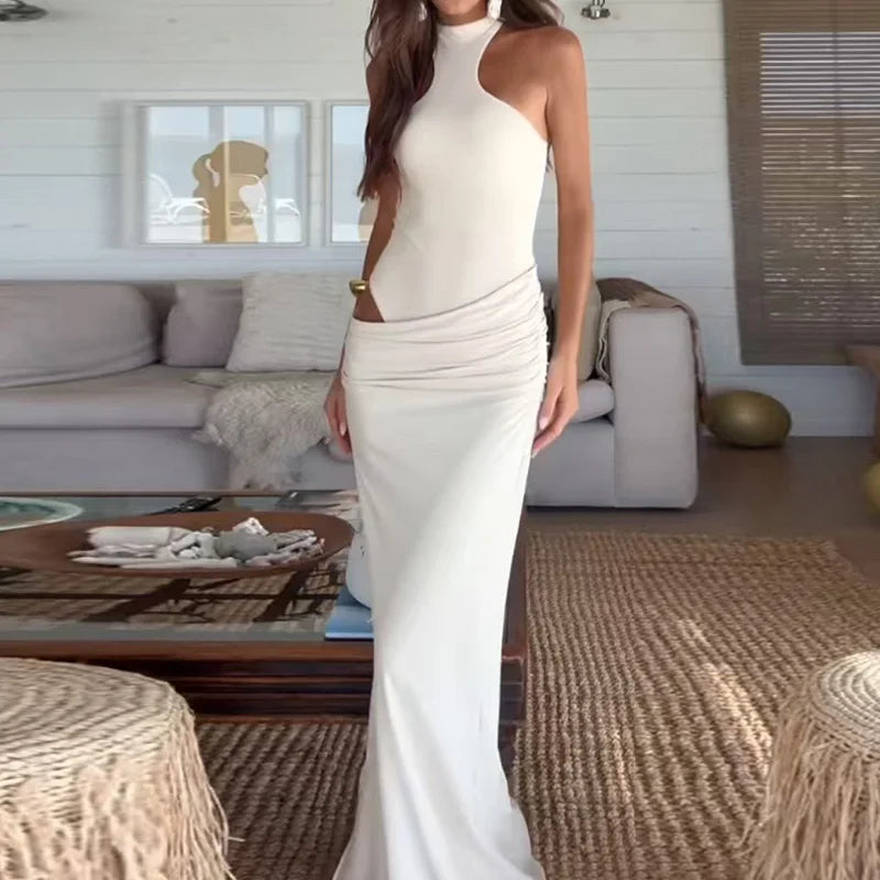 Woman in a white dress standing in a living room.