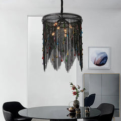  A modern tassel chandelier with cascading crystals, hanging in a luxurious dining room. Golden Atelier 3