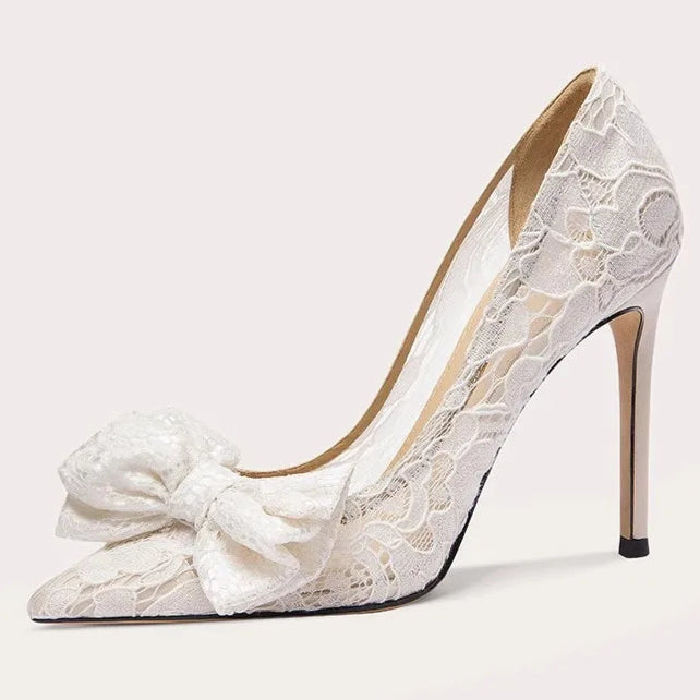 White lace high-heeled shoe with a bow on a light gray background