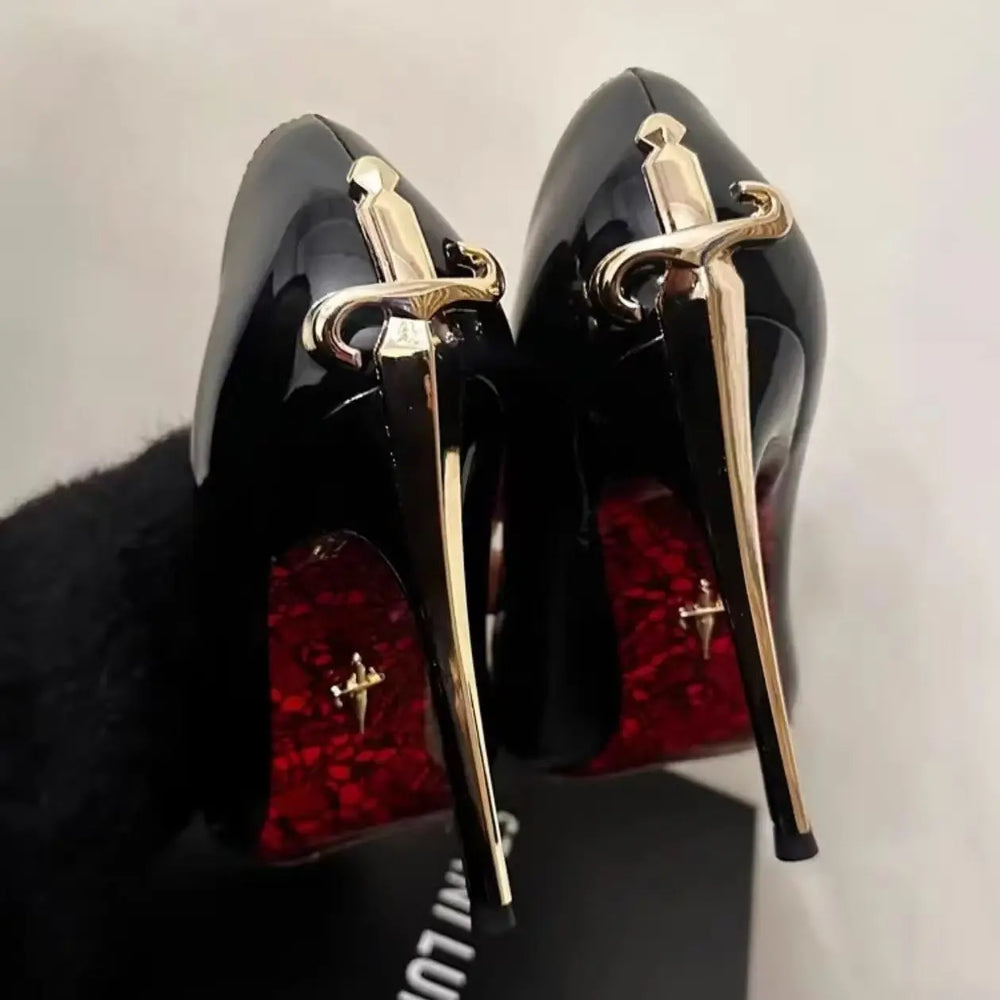 Back view of black stiletto pumps with gold sword heel