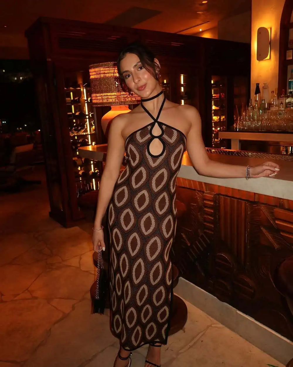Woman in a patterned dress standing in a bar setting