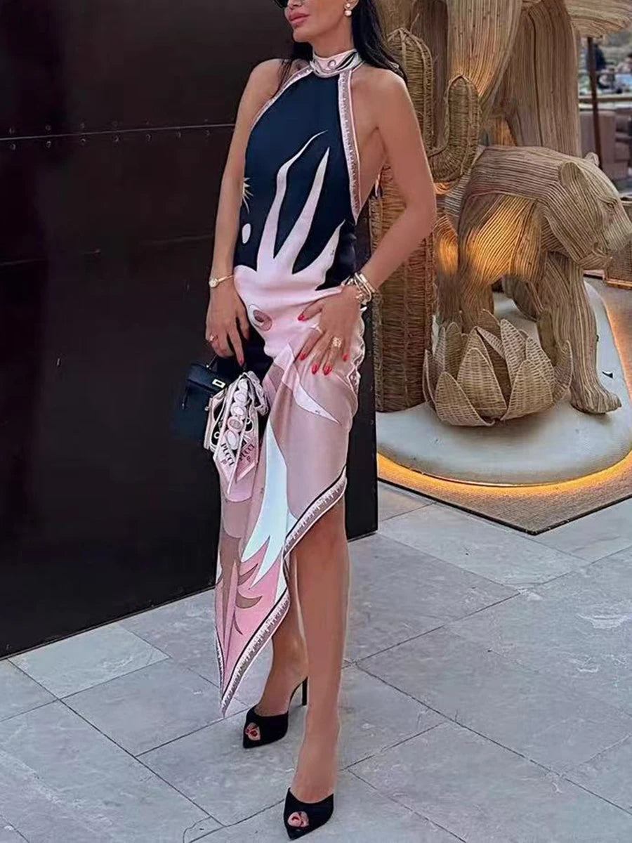 Woman in a black and pink abstract print halter neck maxi dress