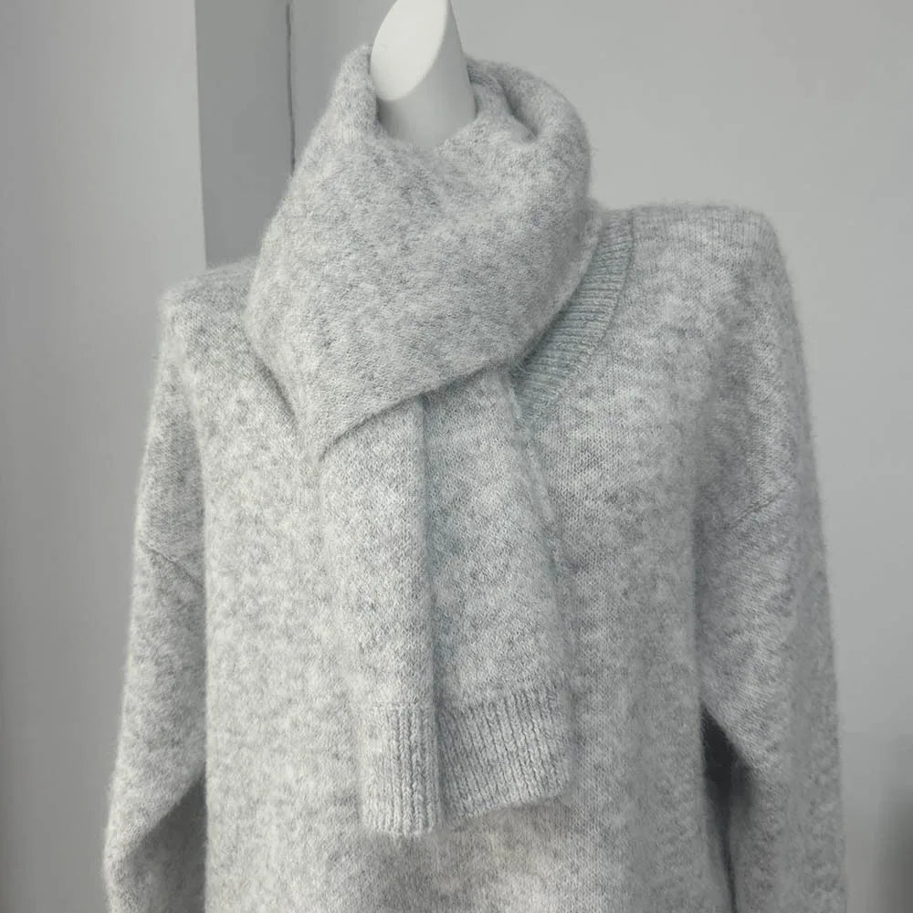 Gray knitted sweater on a mannequin against a plain background