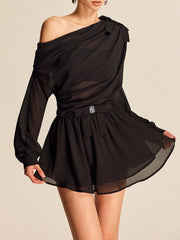 Black one-shoulder dress with sheer panels on a beige background