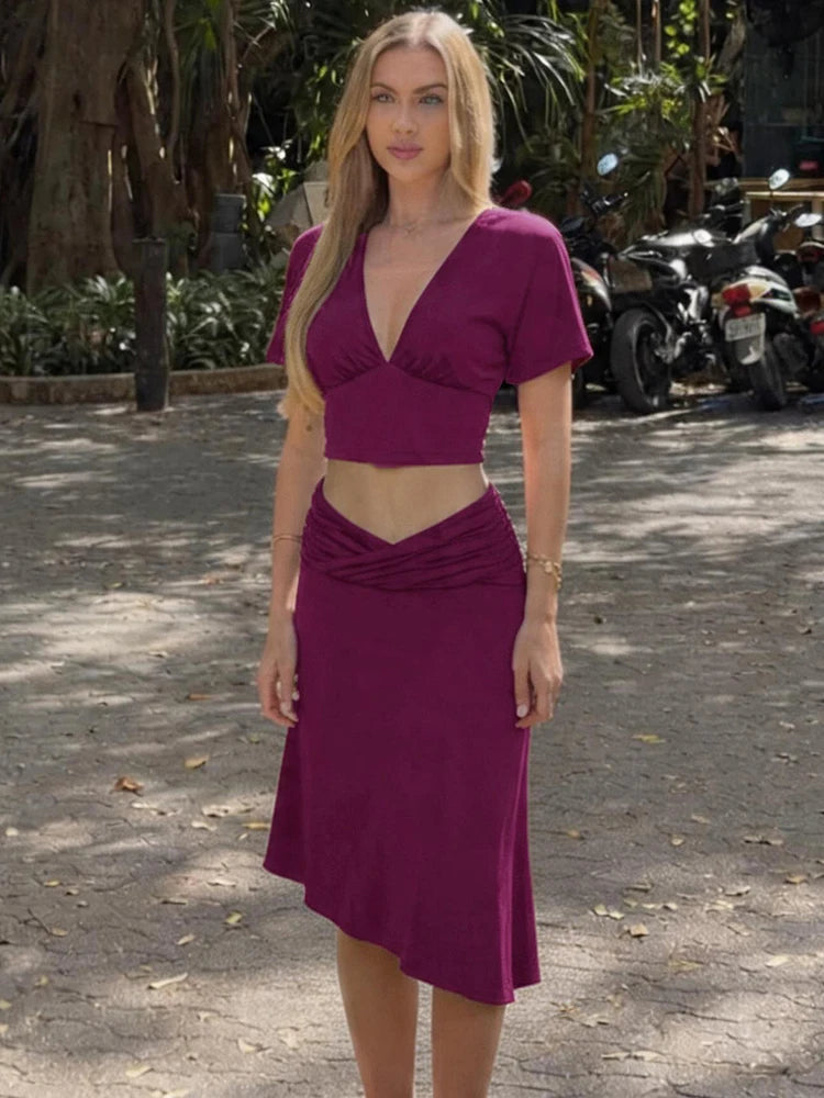 Full body view of a purple v-neck crop top and ruched midi skirt set