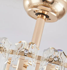 Gold chandelier with crystal elements on a light gray background