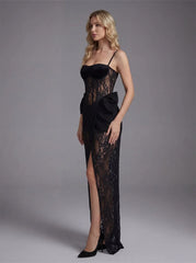 Black lace corset gown with a side split and bow detail, modeled by a woman against a grey background.