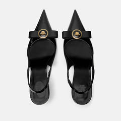 Top view of black pointed toe slingback heels with a bow detail and gold metal accent
