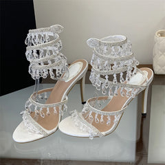 Pair of white crystal ankle strap stiletto heels