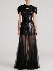 Black sequin mini dress with sheer tulle maxi overlay, featuring cap sleeves and a décolletage cut-out.