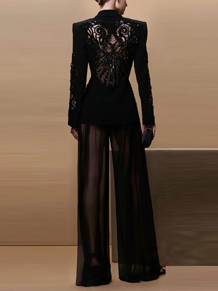 Black outfit with intricate back design on a neutral background