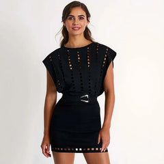 Woman wearing a black dress with cut-out details on a white background
