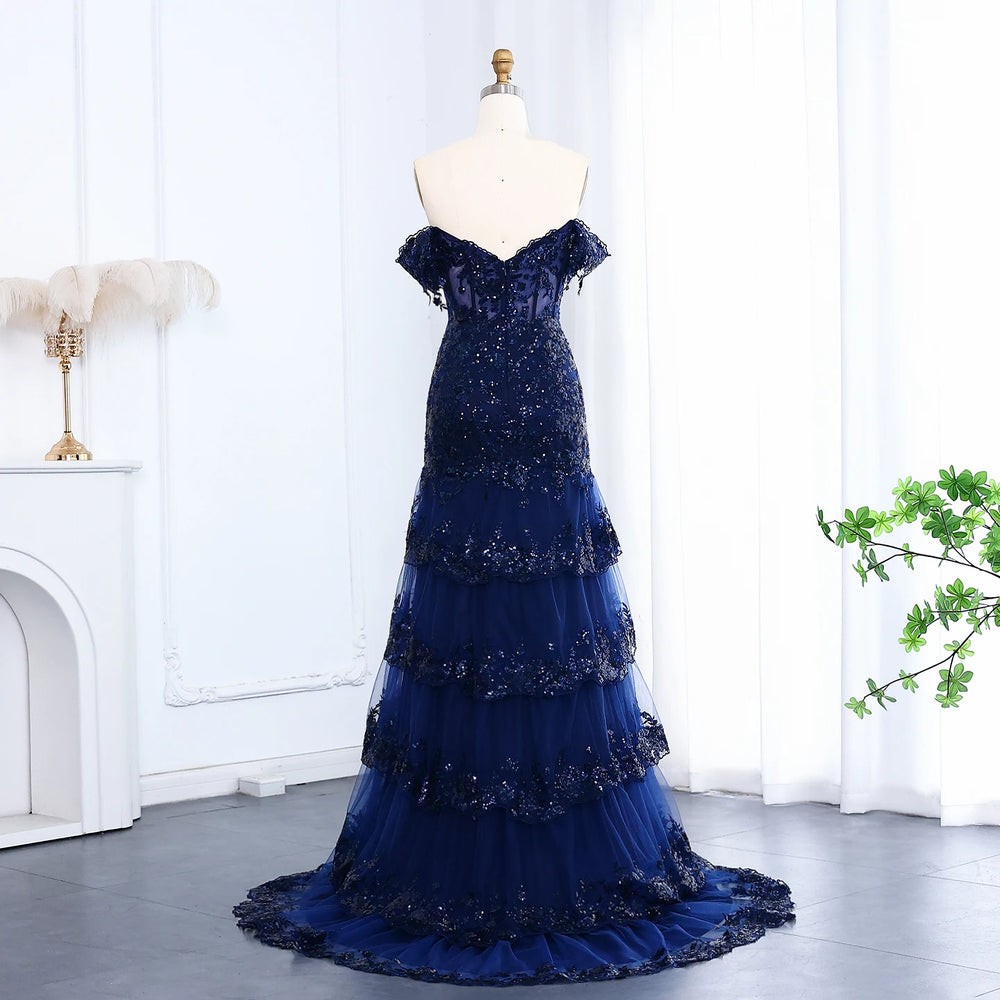 Navy blue evening gown on a mannequin against a white curtain background