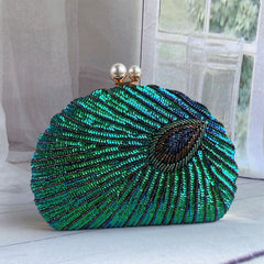 A close-up of a vintage-style clutch bag, showcasing intricate bead embroidery and a clasp closure.