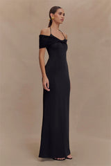 Woman wearing a black off-shoulder gown against a beige background