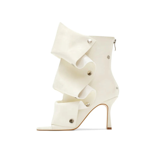 Peep toe stiletto heel boots in off-white with ruffled overlay.