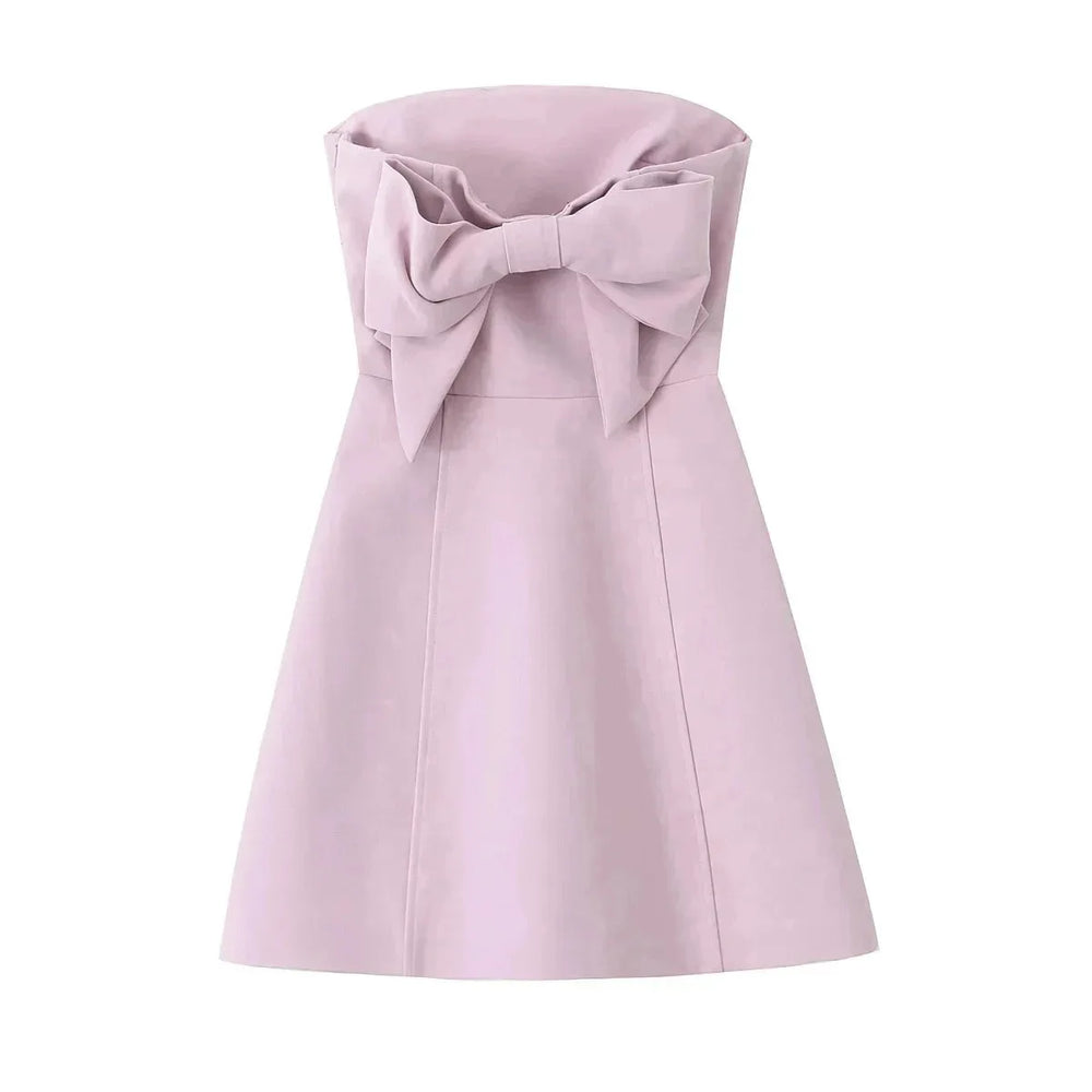 Pink dress with a large bow on a white background